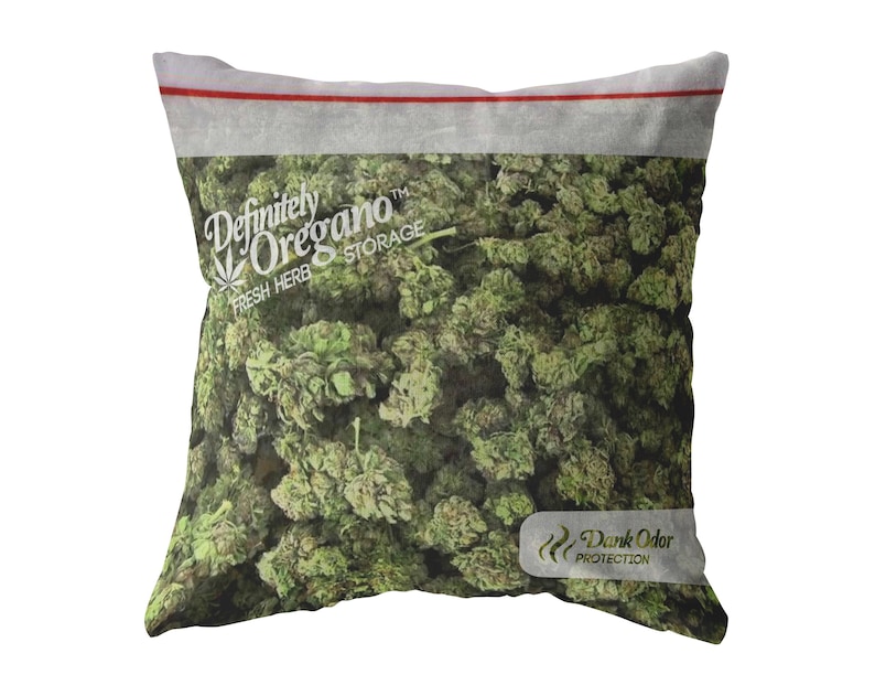 Peut inclure: Un oreiller blanc avec une image imprim&eacute;e d'un sac d'origan vert. Le sac porte l'inscription "Definitely Oregano" et "Fresh Herb Storage". Le sac porte &eacute;galement un petit logo qui dit "Dank Odor Protection".