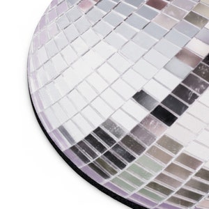 K&ouml;nnte beinhalten: Nahaufnahme einer silbernen Discokugel mit Spiegelkacheln. Die Kacheln sind in einem geometrischen Muster angeordnet und erzeugen einen schimmernden Effekt.