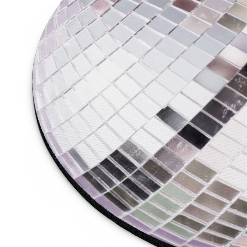 K&ouml;nnte beinhalten: Nahaufnahme einer silbernen Discokugel mit Spiegelkacheln. Die Kacheln sind in einem geometrischen Muster angeordnet und erzeugen einen schimmernden Effekt.