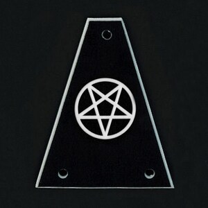 May include: A black, triangular-shaped object with a white pentagram symbol in the center. The object has a clear, beveled edge and three small holes. The background is black.