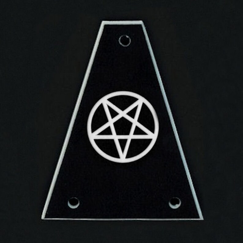 May include: A black, triangular-shaped object with a white pentagram symbol in the center. The object has a clear, beveled edge and three small holes. The background is black.