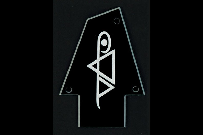 May include: Black guitar pick with a white stylized design. The pick has four screw holes.
