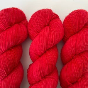 May include: Three skeins of bright red yarn, each wound into a ball shape.
