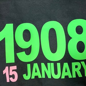 May include: Green and black graphic print on a black t-shirt with the text "1908 15 JANUARY".