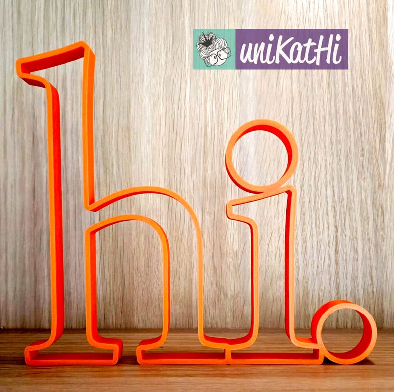 May include: Orange cutout letters spelling "hi" on a wood background. The letters are made of a thick, solid material.