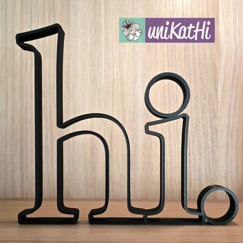 May include: Black metal cutout of the word "hi" with a rounded "i".