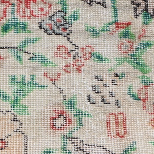 Puede incluir: Primer plano de una tela beige con un patr&oacute;n floral. El patr&oacute;n presenta flores y hojas rojas, verdes y negras.