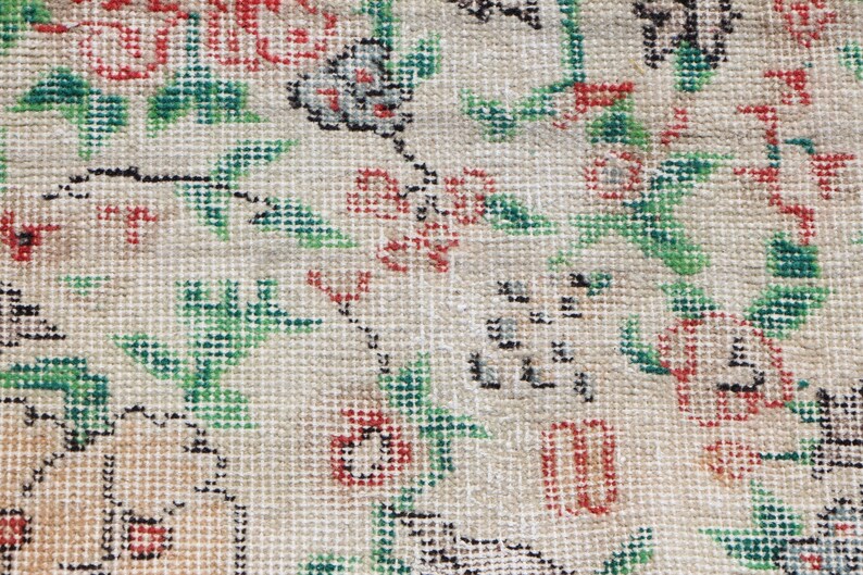 Puede incluir: Primer plano de una tela beige con un patr&oacute;n floral. El patr&oacute;n presenta flores y hojas rojas, verdes y negras.