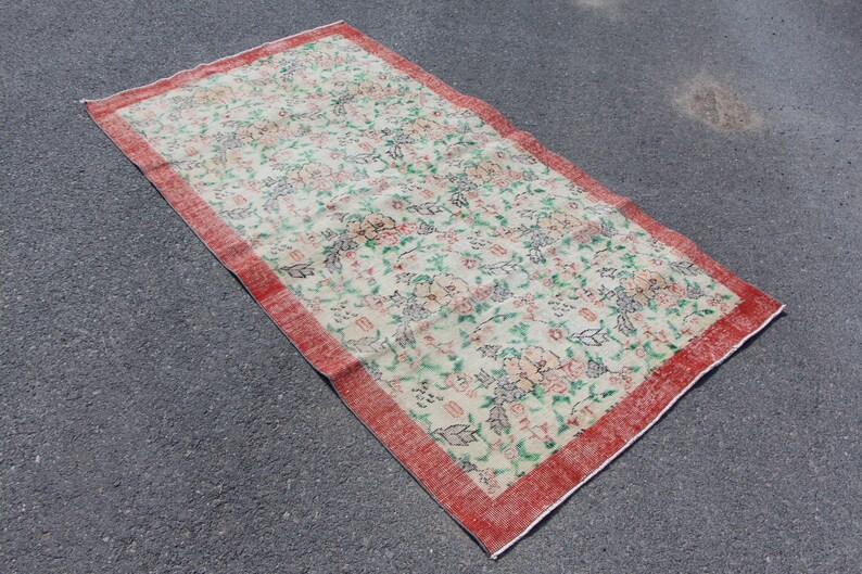 Puede incluir: Una alfombra vintage con estampado floral y borde rojo. La alfombra tiene un fondo crema con dise&ntilde;os florales rosas, verdes y azules.