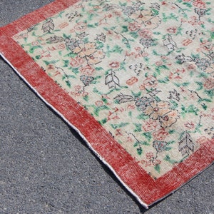 Puede incluir: Una alfombra vintage con estampado floral y borde rojo. La alfombra tiene un fondo crema con dise&ntilde;os florales verdes y rosas.
