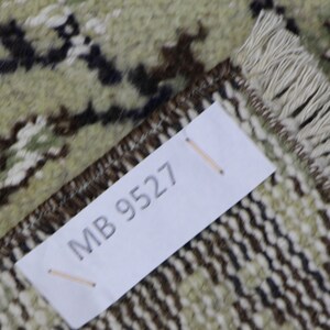 Puede incluir: Primer plano de una alfombra con un patr&oacute;n marr&oacute;n y blanco. Una etiqueta blanca con el texto "MB 9527" est&aacute; unida a la alfombra.