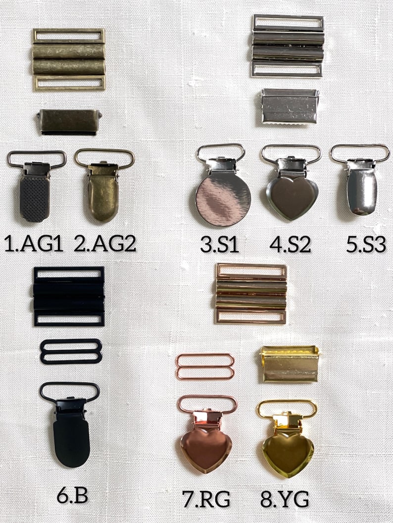 May include: An assortment of metal hardware components, including rectangular sliders, rectangular buckles, and suspender clips. The clips come in various shapes, including round, heart, and rectangular, and in colors like silver, gold, and black.