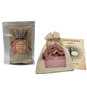 May include: A set of 25 wooden runes in a brown cloth bag with a drawstring closure. The runes are made of cedar wood and have Elder Futhark symbols carved into them. The bag is accompanied by a small booklet titled "The Healer's Way Wooden Rune Set".