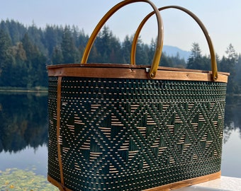 Picnic basket with basket weave pattern. Hinged oblong basket with swing handles, pressboard lid. Dark green diamond weave includes insert