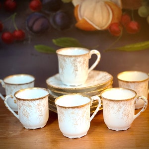 Set of six LIMOGES Demitasse cups and saucers. Gold floral pattern on white ground with gold trim by TNV.