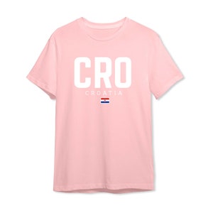 May include: A pink t-shirt with the word "CRO" in white letters and the word "CROATIA" in smaller white letters below. The Croatian flag is displayed below the word "CROATIA".