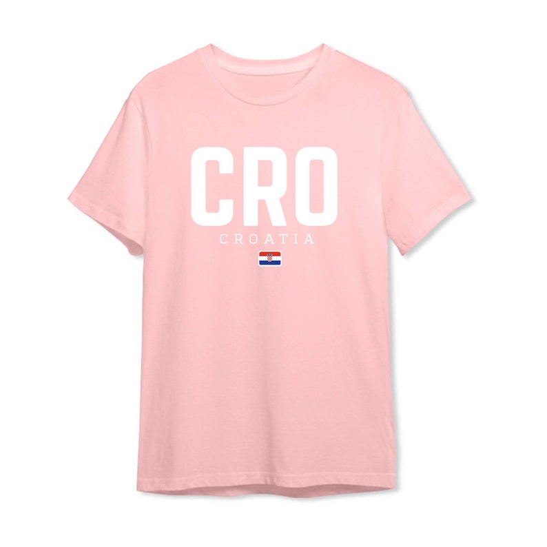 May include: A pink t-shirt with the word "CRO" in white letters and the word "CROATIA" in smaller white letters below. The Croatian flag is displayed below the word "CROATIA".