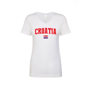 May include: White V-neck t-shirt with the word "CROATIA" in red letters and the Croatian flag printed below.