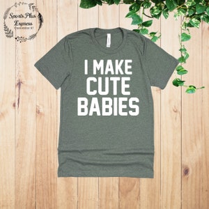 May include: A green t-shirt with the text "I MAKE CUTE BABIES" printed in white.