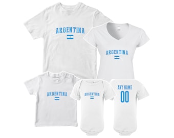 May include: White t-shirts and a baby onesie with the word "ARGENTINA" in blue, along with the Argentinian flag. One shirt has "ANY NAME" and the number "00" on the back.