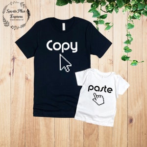 May include: A black t-shirt with the word "Copy" and a white pixelated cursor, and a white t-shirt with the word "Paste" and a white pixelated cursor.