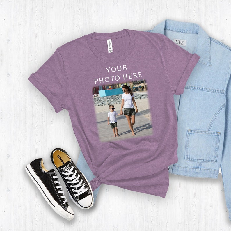 May include: A purple t-shirt with the text "YOUR PHOTO HERE" and a photo of a woman and child walking on a beach.