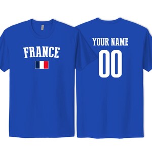 May include: A royal blue short-sleeved t-shirt featuring the word FRANCE in white capital letters above a small French flag. The back of the shirt displays the text YOUR NAME in white capital letters above the large white numbers 00.