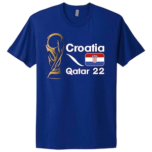 May include: A royal blue t-shirt featuring a gold World Cup trophy graphic, the text "Croatia", the Croatian flag, and the text "Qatar 22".