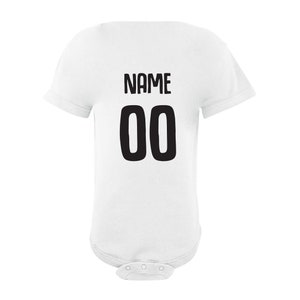 May include: White baby bodysuit with black text that says "NAME 00" on the back.