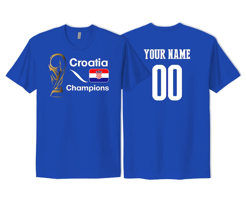 May include: A royal blue t-shirt featuring a gold trophy graphic, the text Croatia Champions, and the Croatian flag on the front. The back of the shirt displays the text YOUR NAME above the number 00 in large white font.