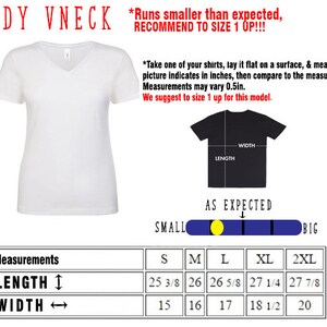 Pu&ograve; includere: Una maglietta bianca a collo a V con una tabella delle taglie che mostra le misure in pollici. La tabella include le taglie S, M, L, XL e 2XL. Il testo dice "Runs smaller than expected, RECOMMEND TO SIZE 1 UP!!"