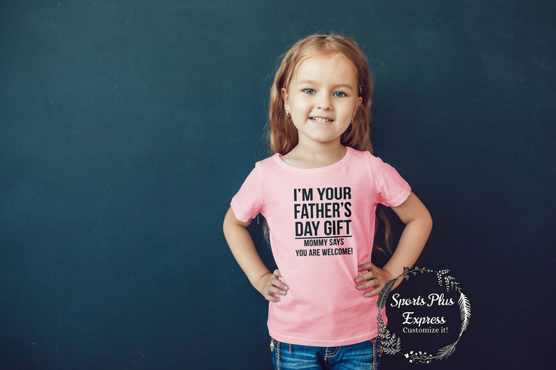 May include: A pink t-shirt with black text that reads "I'm your father's day gift. Mommy says you are welcome!"