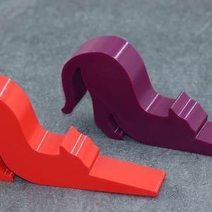 May include: Two doorstop cat figurines, one red and one purple, in a curled up position.
