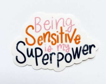 May include: A white sticker with a pink, orange, and black design. The sticker says "Being Sensitive is my Superpower".