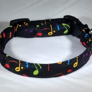 May include: Black dog collar with a colourful musical note pattern.