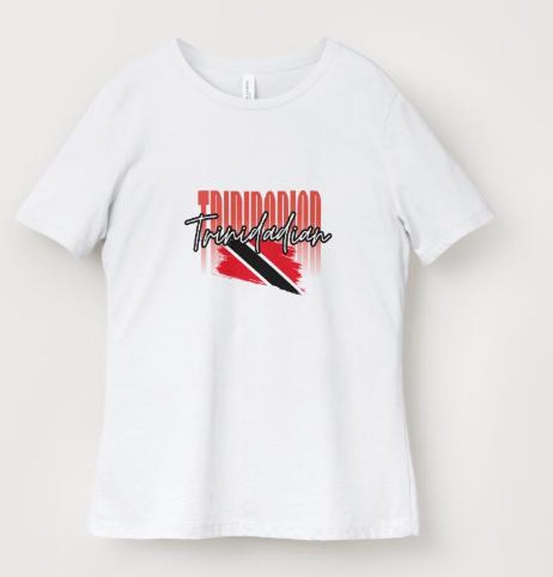 Pu&ograve; includere: T-shirt bianca con la scritta "Trinidadian" in un font stilizzato e il design della bandiera di Trinidad e Tobago. La bandiera &egrave; rossa, nera e bianca. La maglietta &egrave; un modello casual girocollo.