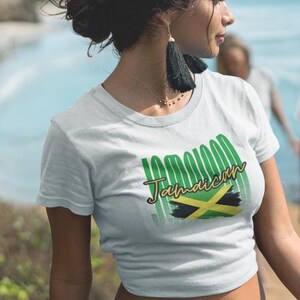 Pu&ograve; includere: T-shirt bianca con la scritta "100% Jamaican" in verde e oro, insieme alla bandiera giamaicana. La maglietta &egrave; a maniche corte e ha un girocollo. Il disegno &egrave; centrato sul davanti.