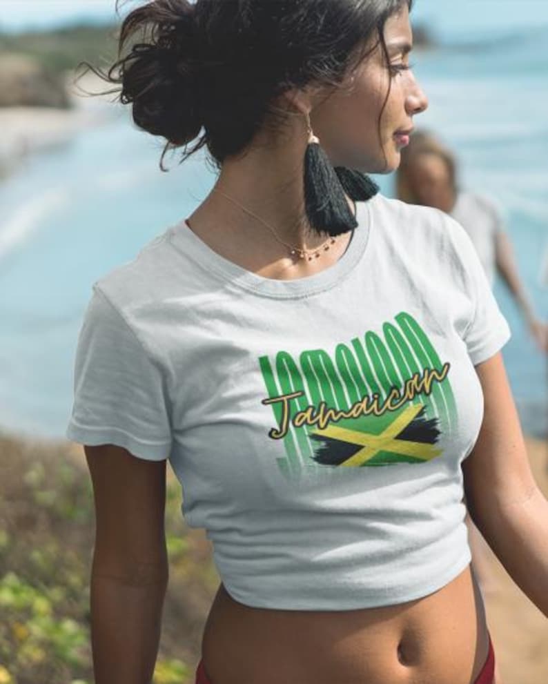Pu&ograve; includere: T-shirt bianca con la scritta "100% Jamaican" in verde e oro, insieme alla bandiera giamaicana. La maglietta &egrave; a maniche corte e ha un girocollo. Il disegno &egrave; centrato sul davanti.