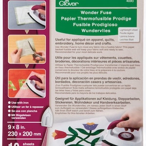 May include: A package of Clover Wonder Fuse, a paper-backed fusible web for appliqué, quilting, and embroidery. The package is green and white, with instructions and examples of use. It measures 9 x 8 inches and contains 10 sheets.