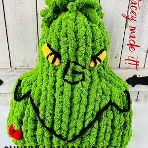 May include: A green, chunky pillow shaped like a character's face, with yellow and black accents for the eyes and a black outline for the mouth. The text "CHUNKY PILLOW PALZ" is at the bottom. The words "Stacey made it!" are written in red.
