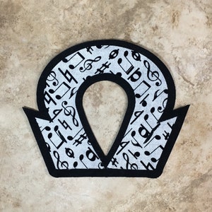 May include: Black and white fabric patch shaped like an omega symbol with musical notes printed on the fabric.