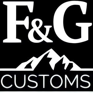 Puede incluir: Logotipo blanco sobre fondo negro con el texto "F&G CUSTOMS". El logotipo presenta una cordillera de monta&ntilde;as estilizada.