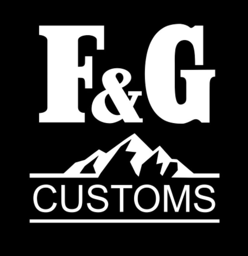 Puede incluir: Logotipo blanco sobre fondo negro. El logotipo presenta las letras "F & G" sobre un gr&aacute;fico de cordillera y la palabra "CUSTOMS" en una fuente sans-serif, subrayada con una l&iacute;nea.