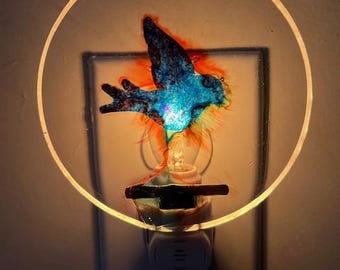 Pájaro azul de fieltro con luz nocturna