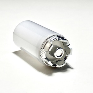 Puede incluir: Una bombilla cilíndrica blanca con una base de metal plateado. La base tiene un diseño decorativo en forma de estrella.