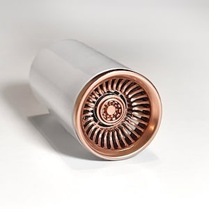 May include: A white and rose gold colored jet engine model. The engine is made of plastic and has a detailed design.