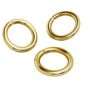 Puede incluir: Tres anillos de salto de oro, cada uno con una forma circular y un acabado liso y pulido.