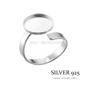 Pode incluir: Um anel de prata com uma moldura redonda. O anel é ajustável e apresenta o texto "SILVER 925" e "FINDINGS - ACCESORIOS - APPRETS". O anel é projetado para fazer joias.