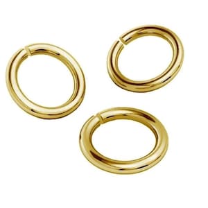 Puede incluir: Tres anillos de salto de oro, cada uno con una forma circular y un acabado liso y pulido.