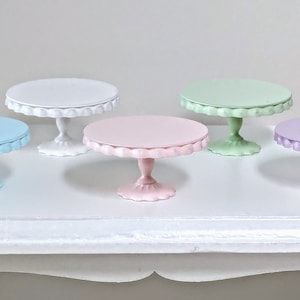 Può includere: Set di sei supporti per torte color pastello con bordi a festoni. I supporti sono in metallo e hanno una base a piedistallo. I colori sono bianco, azzurro, rosa chiaro, verde chiaro, lavanda e giallo.